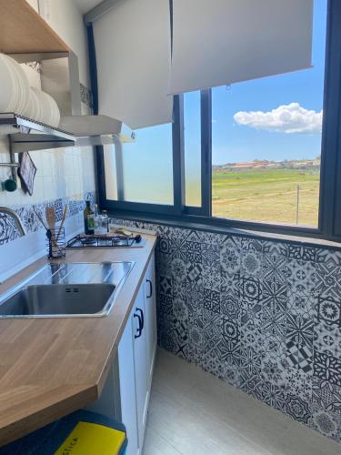 una cucina con un lavello e una grande finestra di Mia House - Appartamento Marzamemi a Marzamemi