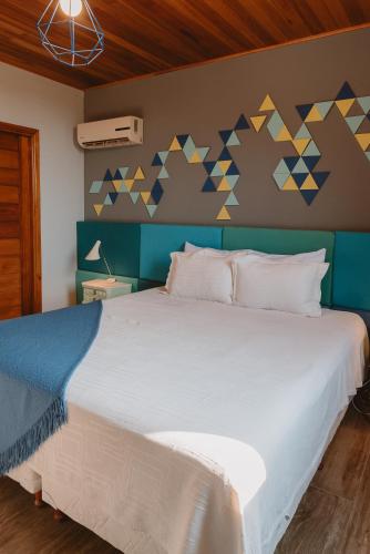 a bedroom with a white bed with a blue and yellow wall at Puerto Dijama Hotel Boutique in Carmelo