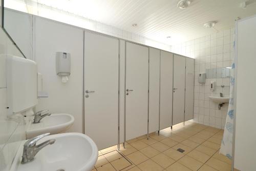 a bathroom with two sinks and a shower with stalls at Hostel Filaretai in Vilnius