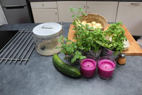 a counter with a cutting board with plants and purple candles at Le Néblon insolite in Ouffet