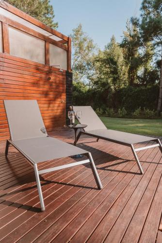 two lounge chairs sitting on a wooden deck at Puerto Dijama Hotel Boutique in Carmelo