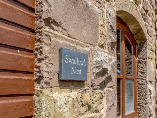 a sign on the side of a stone building at Swallow's Nest in Craven Arms