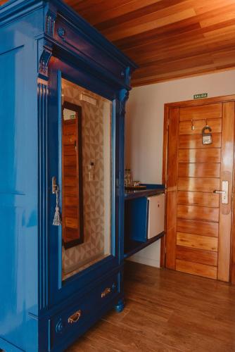 a blue room with a door and a kitchen at Puerto Dijama Hotel Boutique in Carmelo