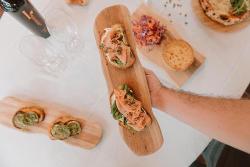 a person holding a sandwich on a table with food at Puerto Dijama Hotel Boutique in Carmelo
