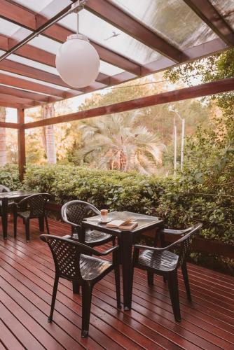 a patio with tables and chairs on a wooden deck at Puerto Dijama Hotel Boutique in Carmelo