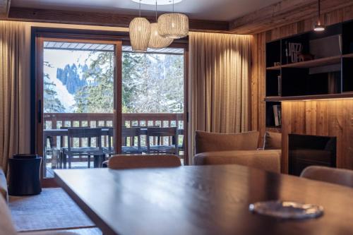 un salon avec une table et une grande fenêtre dans l'établissement Antarès URSA 203 - luxury apartment ski inski out, à Méribel