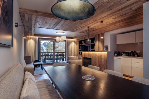 un salon avec une table de salle à manger et une cuisine dans l'établissement Antarès URSA 203 - luxury apartment ski inski out, à Méribel