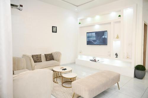 a white living room with a couch and a table at NEW LUXURY 3BED TERRACE DUPLEX APARTMENt in Lekki