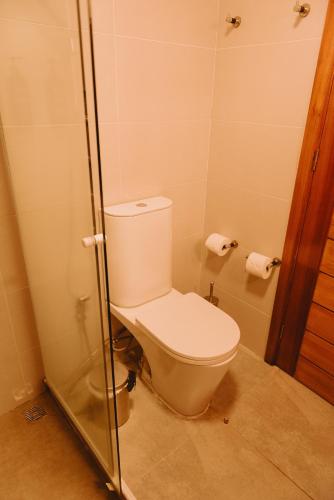 a bathroom with a toilet with a glass shower door at Puerto Dijama Hotel Boutique in Carmelo