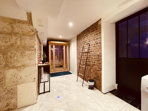 una camera con un muro di mattoni e un bancone di Luxe Caché Balnéo et Sauna Privés - 372 a Rouen