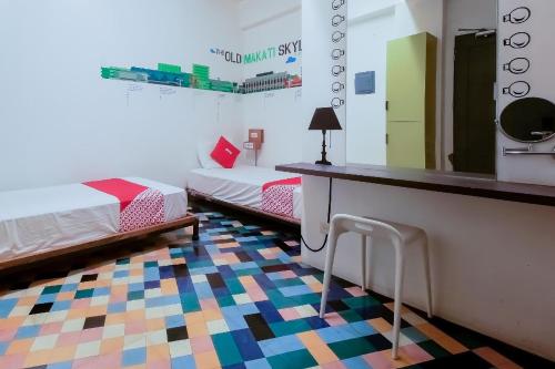 a room with two beds and a counter with a mirror at Junction Hostel, Poblacion Makati Avenue, Manila in Manila