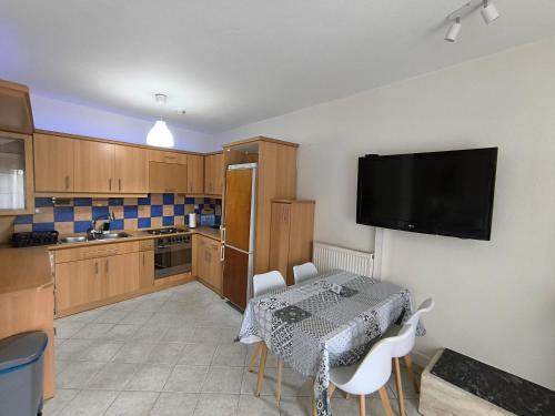 a kitchen with a table and a television on the wall at Cozy Houses One in Kavala