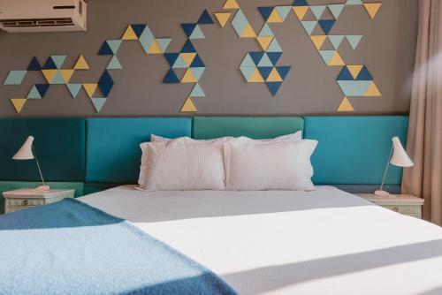 a bedroom with a bed with a blue headboard at Puerto Dijama Hotel Boutique in Carmelo