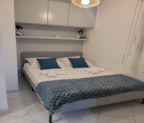 - un lit avec des oreillers bleus et blancs dans l'établissement centre cannes musiciens, à Cannes