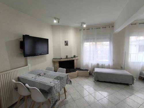 a living room with a table and a tv on the wall at Cozy Houses One in Kavala