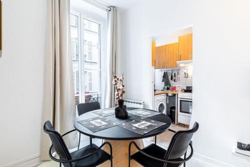 une cuisine avec une table et des chaises dans une pièce dans l'établissement GuestReady - Beau Séjour près de Champs de Mars, à Paris