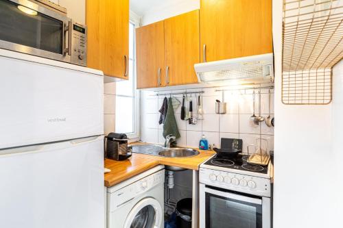 - une cuisine équipée d'un lave-linge, d'un évier et d'une cuisinière dans l'établissement GuestReady - Beau Séjour près de Champs de Mars, à Paris