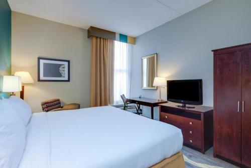a hotel room with a bed and a flat screen tv at Holiday Inn Express Washington DC East- Andrews AFB by IHG in Camp Springs