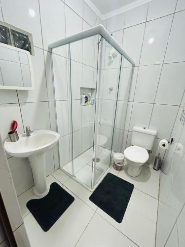 a bathroom with a shower and a toilet and a sink at Casa em Bertioga com piscina aquecida Sitio família ROCHA in Bertioga