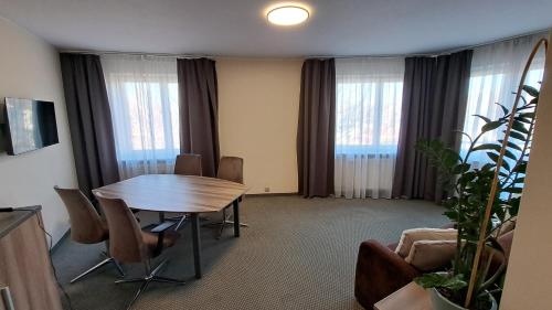 a room with a table and chairs and windows at Poleczki Residence Apartments in Warsaw
