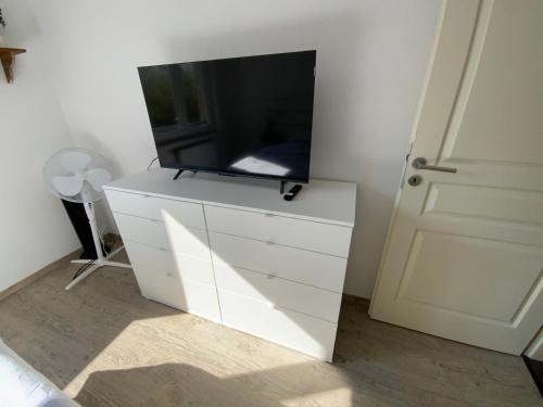 a white dresser with a tv on top of it at Flat near Strasbourg in Offendorf