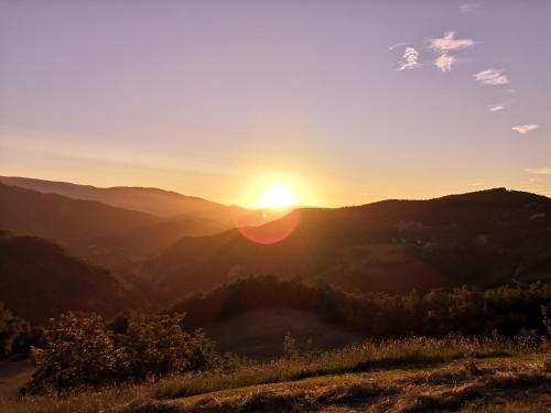 a sunset in the mountains with the sun setting at Bosco Stellato in Casteldelci