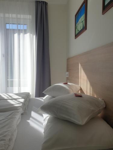 a bedroom with two beds with pillows and a window at Pokoje Sandra I in Łeba