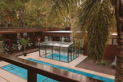 a house with a swimming pool and a palm tree at Puerto Dijama Hotel Boutique in Carmelo