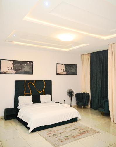 a bedroom with a white bed with a black headboard at NEW LUXURY 3BED TERRACE DUPLEX APARTMENt in Lekki