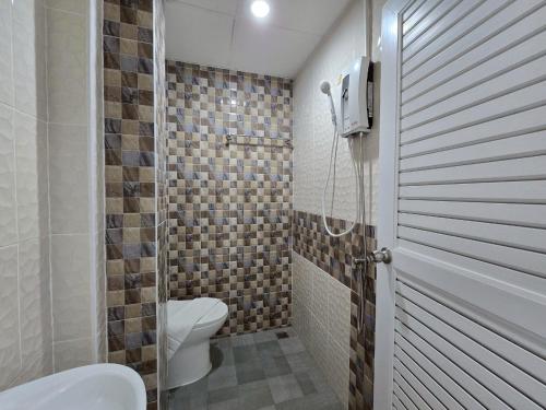 a bathroom with a shower with a toilet and a shower at The White Residence in Chanthaburi