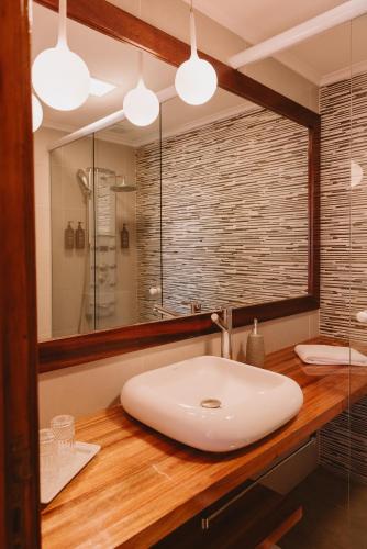 a bathroom with a white sink and a mirror at Puerto Dijama Hotel Boutique in Carmelo