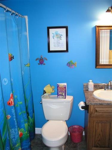 a blue bathroom with a toilet and a sink at Two Eagles Lodge in Union Bay