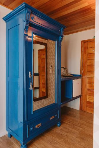 a blue cabinet with a mirror in a kitchen at Puerto Dijama Hotel Boutique in Carmelo