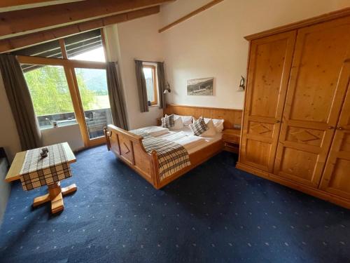 a bedroom with a bed and a wooden cabinet at Gästehaus Tanneck in Reit im Winkl