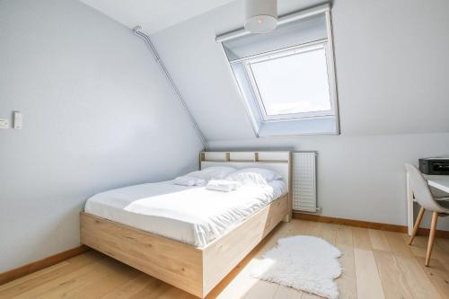 - une chambre avec un lit doté d'une lucarne et d'une fenêtre dans l'établissement L'Atoll Wifi Jardin Parking, à Beaucouzé