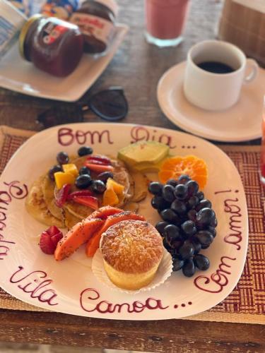 a plate of breakfast food with fruit and a cup of coffee at Pousada Vila Canoa in Canoa Quebrada