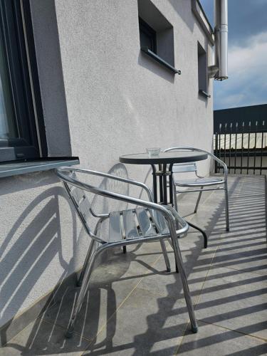 two chairs and a table on a patio at Filipovic rent a car & apartments in Selnica Šćitarjevska