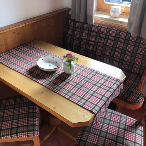 a table with a plate and flowers on top of it at Gästehaus Tanneck in Reit im Winkl