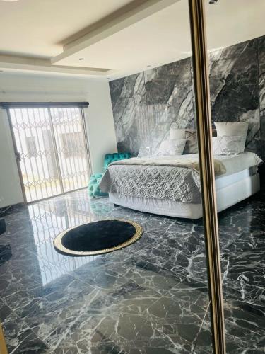 a bedroom with a bed and a mirror at National Lodge in Benoni
