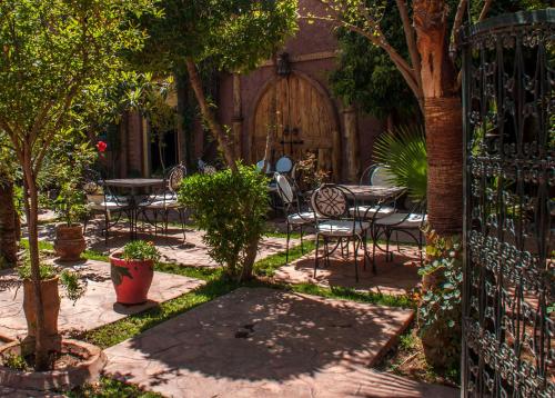 a patio with tables and chairs and a gate with a table and chairs at Hôtel Chellal ďOuzoud in Ouzoud
