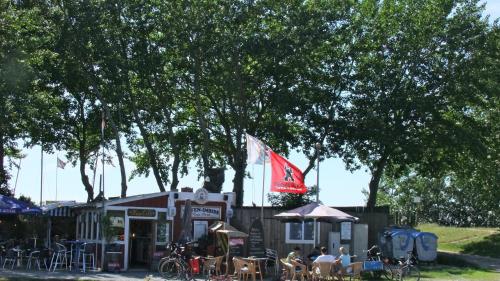 a restaurant with tables and chairs and a flag at Direkt am Meer in Fehmarn