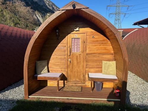 a wooden gazebo with two chairs and a door at Inn-side ADVENTURE CABINS in Haiming