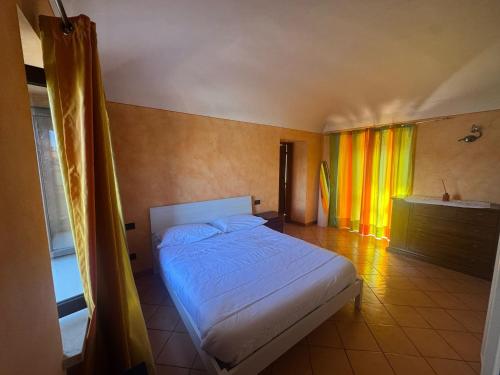 a bedroom with a white bed and a window at Emma Lake Apartment lago di Viverone in Viverone