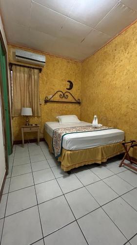 a bedroom with a bed in a yellow wall at La Posadita de Bolonia in Managua