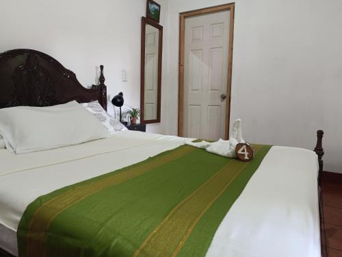 a bed with a green blanket and a purse on it at Casa de Los Berrios in León