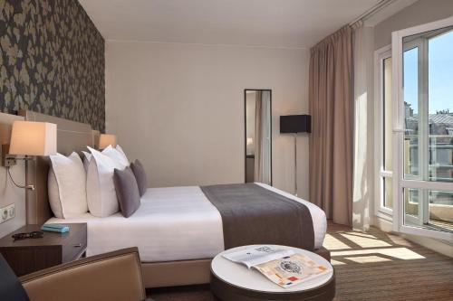 a hotel room with a large bed and a window at Timhotel Opéra Blanche Fontaine in Paris