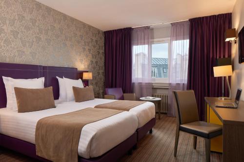 a hotel room with a large bed and a desk at Timhotel Opéra Blanche Fontaine in Paris