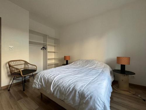 - une chambre avec un lit, une chaise et des lampes dans l'établissement Les gîtes cherois esprit moderne 8 personnes, à Les Chères