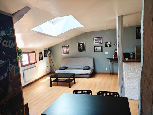 a room with a bed and a table and a skylight at Ciné Loft 55 m2 Centre Ville in Châlons-en-Champagne