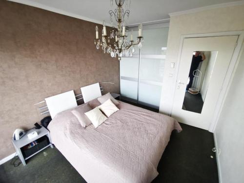 コクセッドにあるAppartement 1 chambre Twenty One Vue imprenable sur la merのベッドとシャンデリアのある寝室